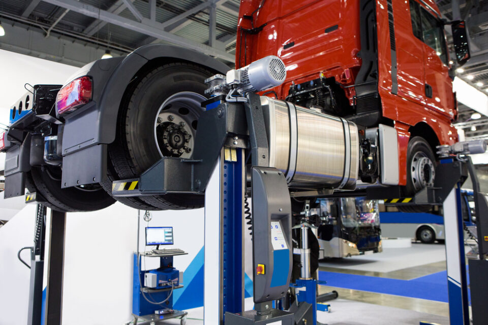 A semitruck on a lift in a garage.